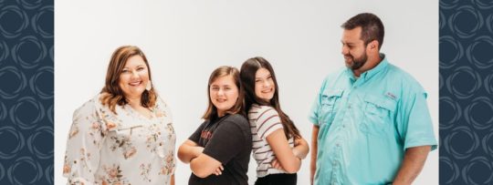 A family of four poses for a photo