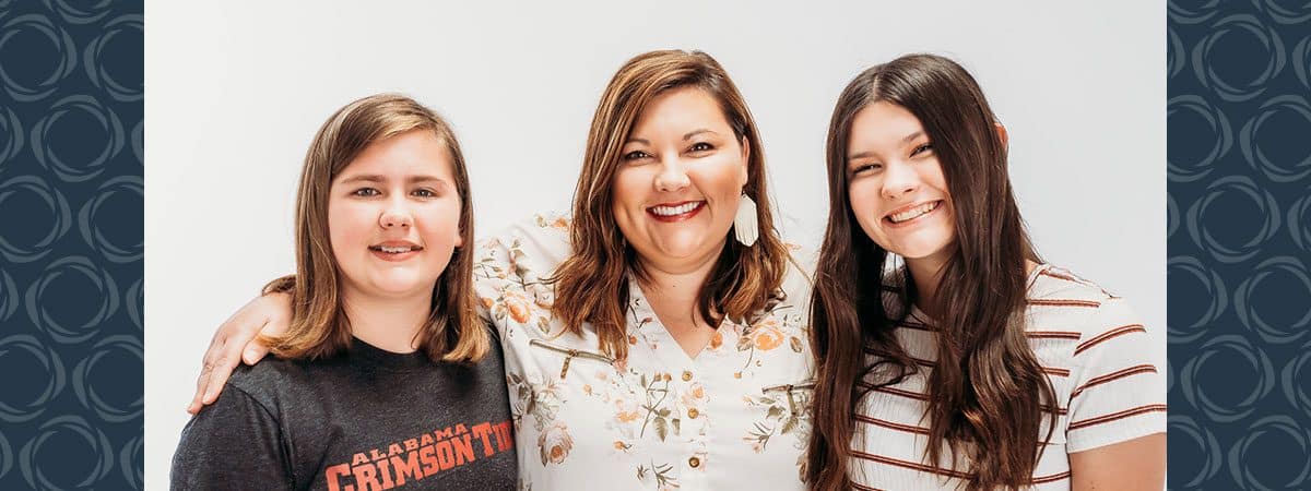 A woman poses for a photo with her two children