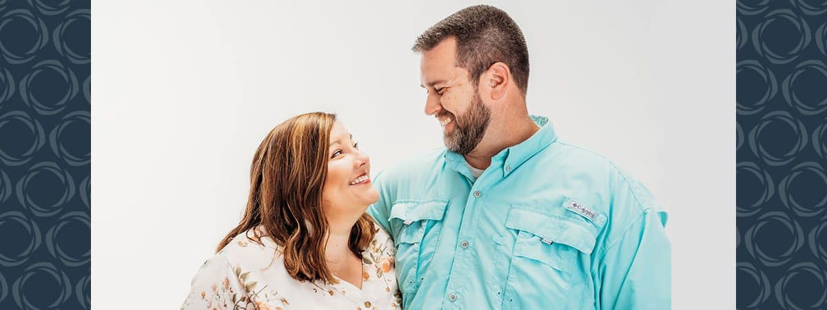 A man and woman look towards each other.