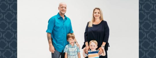 A family of four pose for a photo.