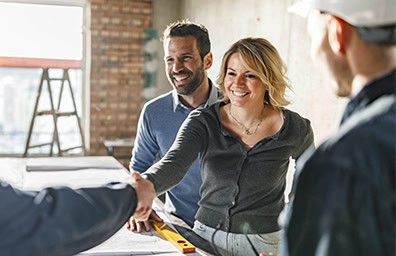 Group of smiling architects shaking hands in an office setting