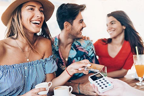 Woman paying with a smart card in cafe