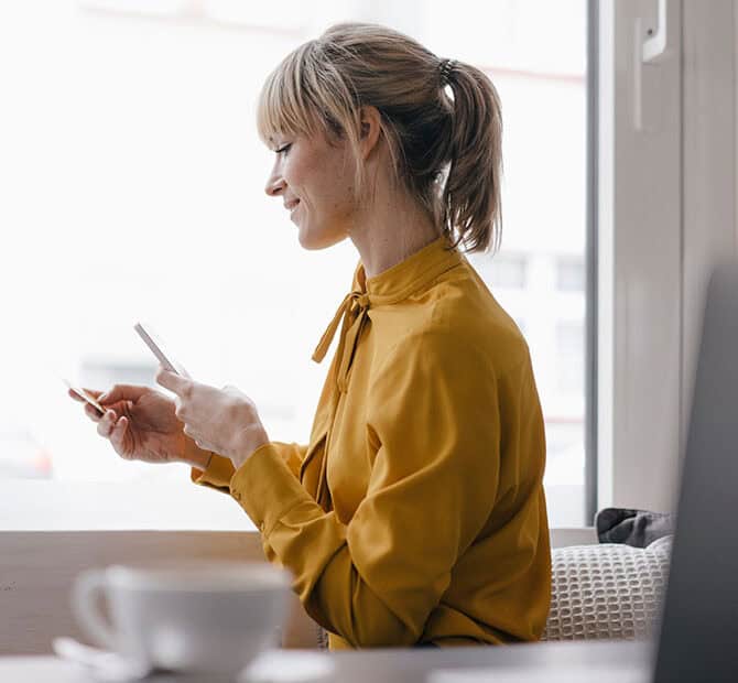 Woman looking at phone and credit card