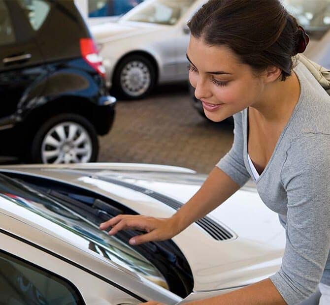 Woman looking at car inside a dealership