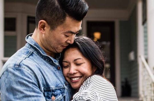 Couple hugging outside of home