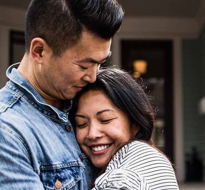 Couple hugging outside of home