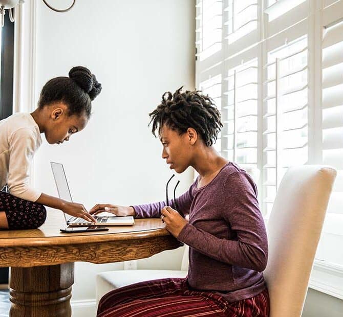 woman with daughter at table with laptop
