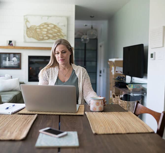 Woman home with laptop at table