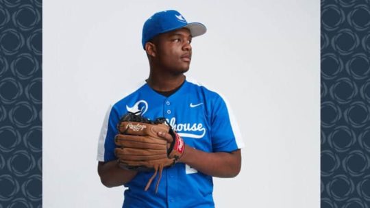 A boy dressed in baseball  uniform with a glove