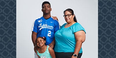 A family of three pose for a photo