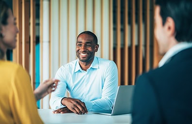 man happily smiles while meeting with customers