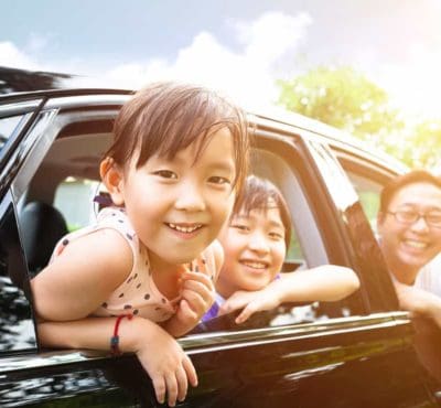Happy family smiling and looking out car windows