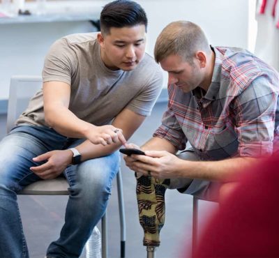 Two veterans looking at a cell phone together