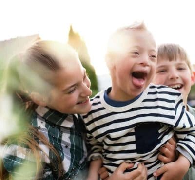 Three happy siblings laughing and having fun