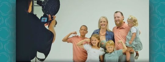 A family stands together posing for a picture