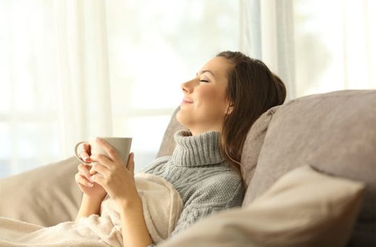 Woman relaxing at home holding a coffee mug