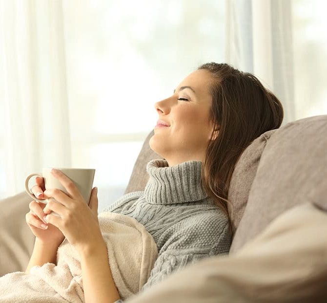Woman relaxing at home holding a coffee mug